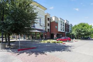 a red car parked in a parking lot next to a building at Spacious 1-bedroom apartment with modern comforts in Dallas