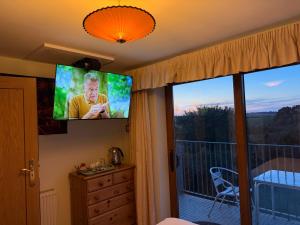a bedroom with a flat screen tv on the wall at Orchard Manor in Probus