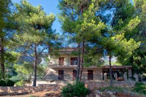 a large house with trees in front of it at Lovely apartments Balić in Ivan Dolac