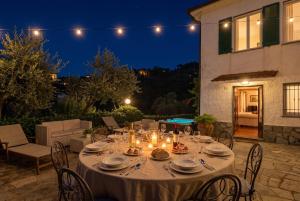 a table set up on a patio at night at Villa with Pool e Jacuzzi Free Parking AC in San Lorenzo della Costa