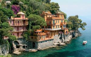 a large building on the side of a mountain in the water at Villa with Pool e Jacuzzi Free Parking AC in San Lorenzo della Costa