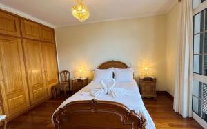 a bedroom with a bed with a bow on it at Vila Boehémia in Canhas