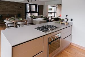 a kitchen with a stove top oven next to a living room at Altitud Medellín Viem Living in Medellín +18 photos