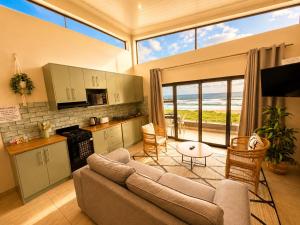 a living room with a couch and a kitchen at White Sands Self-catering units in Wilderness