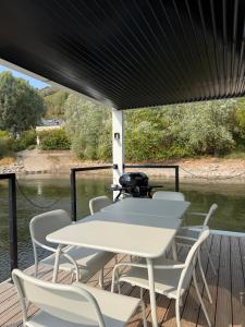 a table and chairs on the deck of a boat at Design-Hausboot am Rheinsteig in Lorch am Rhein