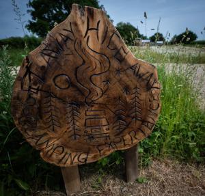 a wooden sign with writing on it in a field at Get Away Hide Away in East Dereham