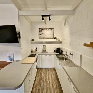 a kitchen with white cabinets and a sink at Prom Coast Apartments in Sandy Point