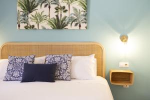 a bedroom with a bed with blue and white pillows at NEW CASA BLU - Oasis Tamarindo 1 in Corralejo