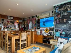 a dining room with a table and a tv at Hostal Maitencillo Norte in Maitencillo
