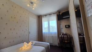 a small room with a bed and a window at Hôtel Le Pommeil in Guéret