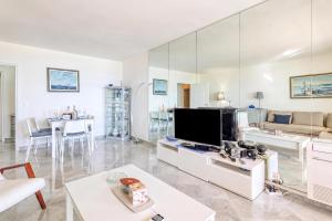 a living room with a large television and a couch at Victoria Palace Elegant Apt with Terrace in Menton