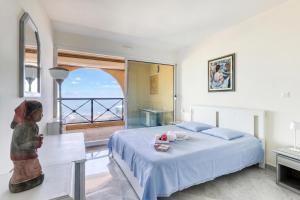 a bedroom with a bed and a view of the ocean at Victoria Palace Elegant Apt with Terrace in Menton