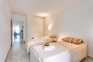 a room with two beds and a table with flowers on it at Victoria Palace Elegant Apt with Terrace in Menton +36 photos