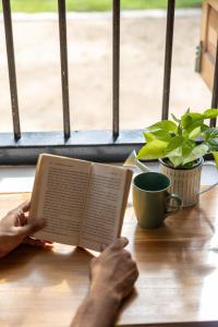 a person sitting at a table reading a book at Don Padris Estate Bungalow in Tangalle