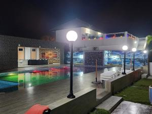 a house with a swimming pool at night at Nima Resort et Suites in Mandanou +79 photos
