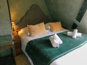a bedroom with a bed with two rolled towels on it at La Maison Bleue - Historic House in the Heart of Riquewihr in Riquewihr