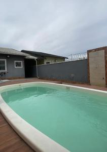 an empty swimming pool in front of a house at Casa em Maricá- Paraiso Itaipuaçu in Maricá