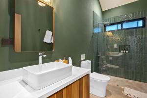 a bathroom with a sink and a toilet and a shower at Selvatico Tamarindo Villas in Tamarindo +24 photos