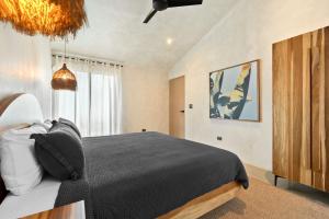 a bedroom with a black bed and a window at Selvatico Tamarindo Villas in Tamarindo
