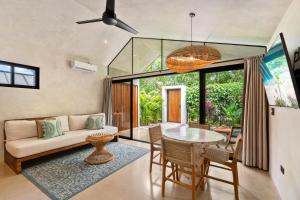 a living room with a couch and a table at Selvatico Tamarindo Villas in Tamarindo