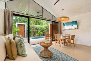 a living room with a couch and a dining room at Selvatico Tamarindo Villas in Tamarindo