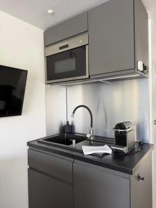 a kitchen with a sink and a microwave at Design-Hausboot am Rheinsteig in Lorch am Rhein