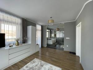 an empty living room with a television and a living room at Panorama Lake Resort in Bezidu Nou