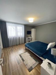 a bedroom with a large blue bed in a room at Panorama Lake Resort in Bezidu Nou