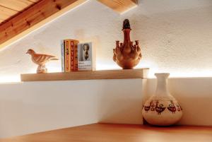 a shelf with a vase and books on it at Aegean Stories pelagos suites in Avlákia