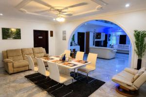 a dining room with a table and chairs and a couch at Big Papa Hotel in Amasaman
