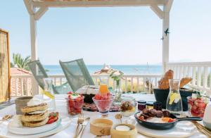 a table with food on it with the beach in the background at Aegean Stories pelagos suites in Avlákia