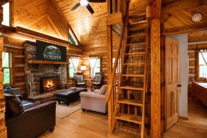 a living room with a fireplace in a log cabin at The Ridge in Cherokee