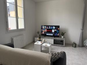 a living room with a tv and a couch at Chez Ben et Lou in Envermeu