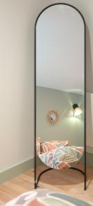 a glass bed with a lamp on a wooden floor at Le Perchoir d'Orthez in Orthez