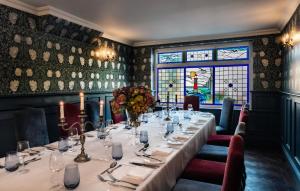 a dining room with a long table and a window at Langham Hotel Eastbourne in Eastbourne