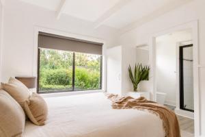 a bedroom with a bed and a large window at Prom Coast Apartments in Sandy Point