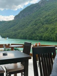a table and chairs on a balcony with a view of the water at Drini Guesthouse in Tropojë