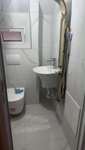 a white bathroom with a sink and a toilet at Drini Guesthouse in Tropojë