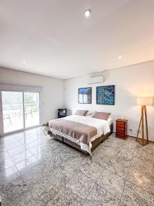 a bedroom with a large bed and a large window at Makai Hotel Boutique - Frente Mar in Guarujá +1 photo