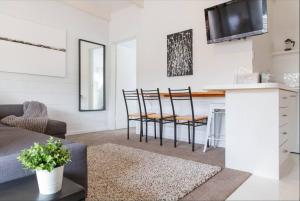 a kitchen and living room with a table and chairs at Prom Coast Apartments in Sandy Point +65 photos