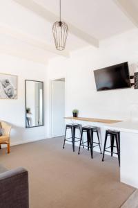 a living room with a table and stools at Prom Coast Apartments in Sandy Point