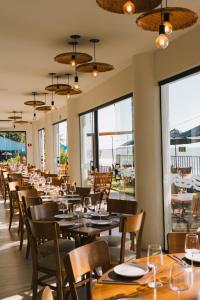 a dining room with tables and chairs and windows at Hotel Resort Rio Poty in São Luís