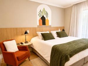 a bedroom with a bed and a chair at Pousada Telhado de Ouro in Campos do Jordão