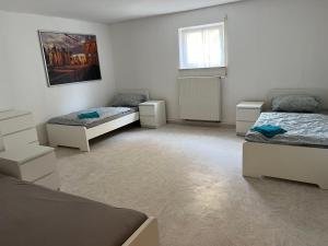 a bedroom with two beds and a window at Ruhig gelegene Ferienwohnung in Waldbrunn
