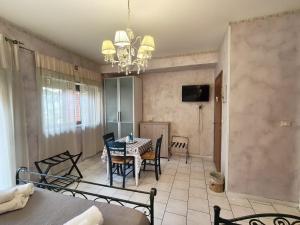 a dining room with a table and chairs and a chandelier at B&B Santa Sofia in Gravina di Catania