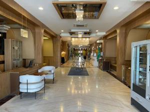 a lobby of a store with white chairs and tables at شير فل الرس in Ar Rass
