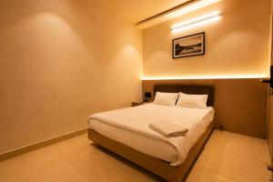 a bedroom with a bed and a picture on the wall at Hotel River Front in Kota