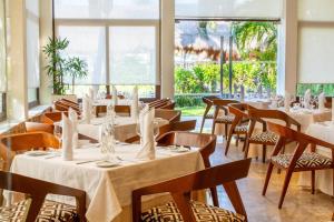 a row of tables and chairs in a room with windows at Akumal Bay Beach & Spa Resort in Akumal