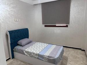 a bedroom with a blue bed in a room at Appartement in Khouribga
