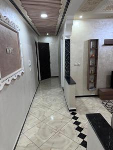a hallway with a black door and a tile floor at Appartement in Khouribga